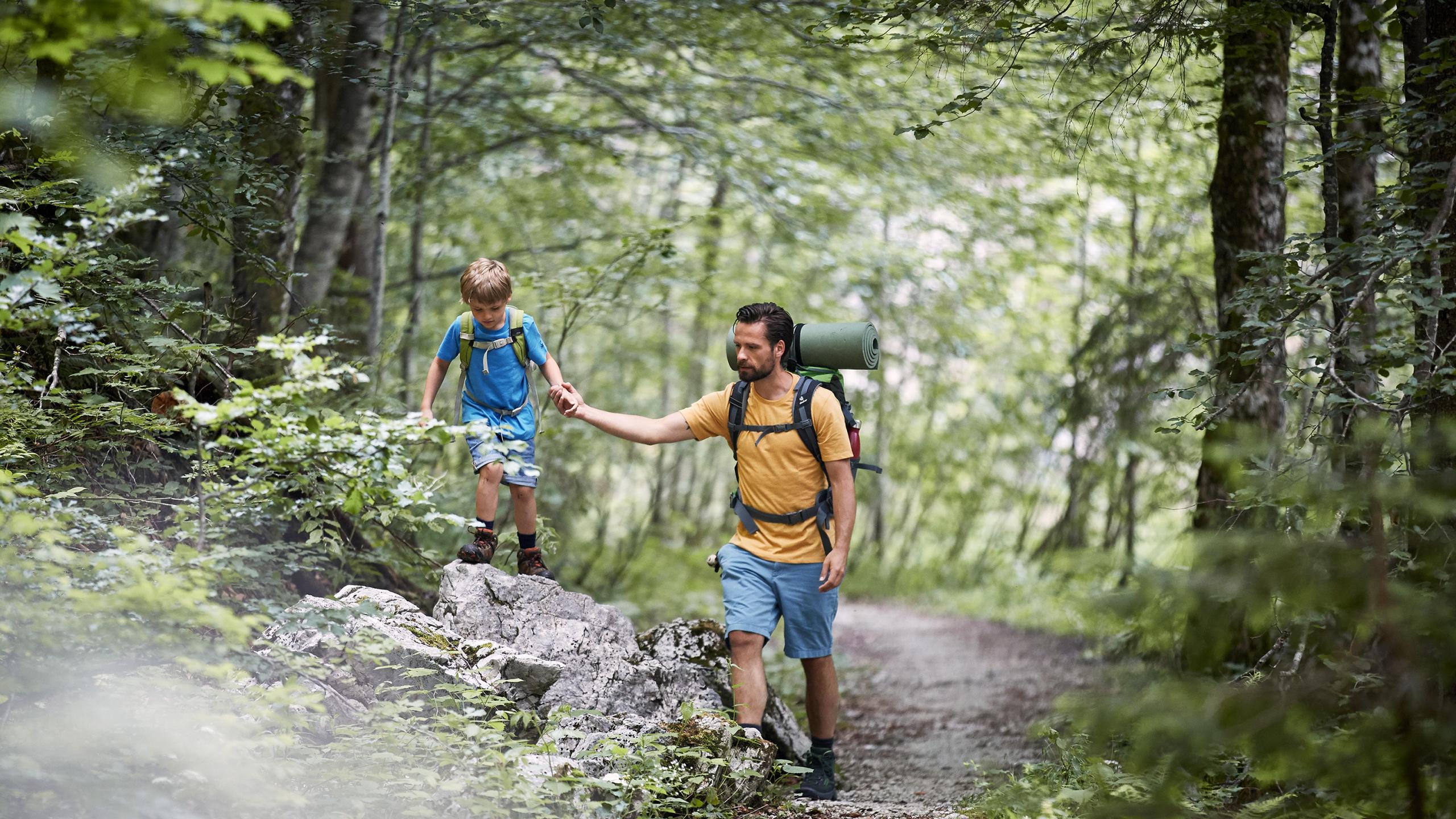 Father and son hiking on a forest path