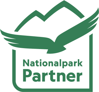 National Park Partner logo in green lettering with a stylized golden eagle above it