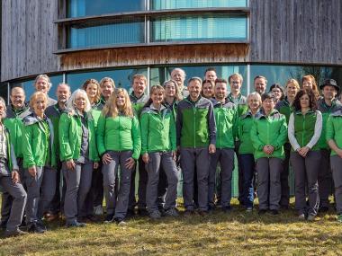 Group photo of Kalkalpen National Park employees in front of Nationalpark Zentrum Molln.