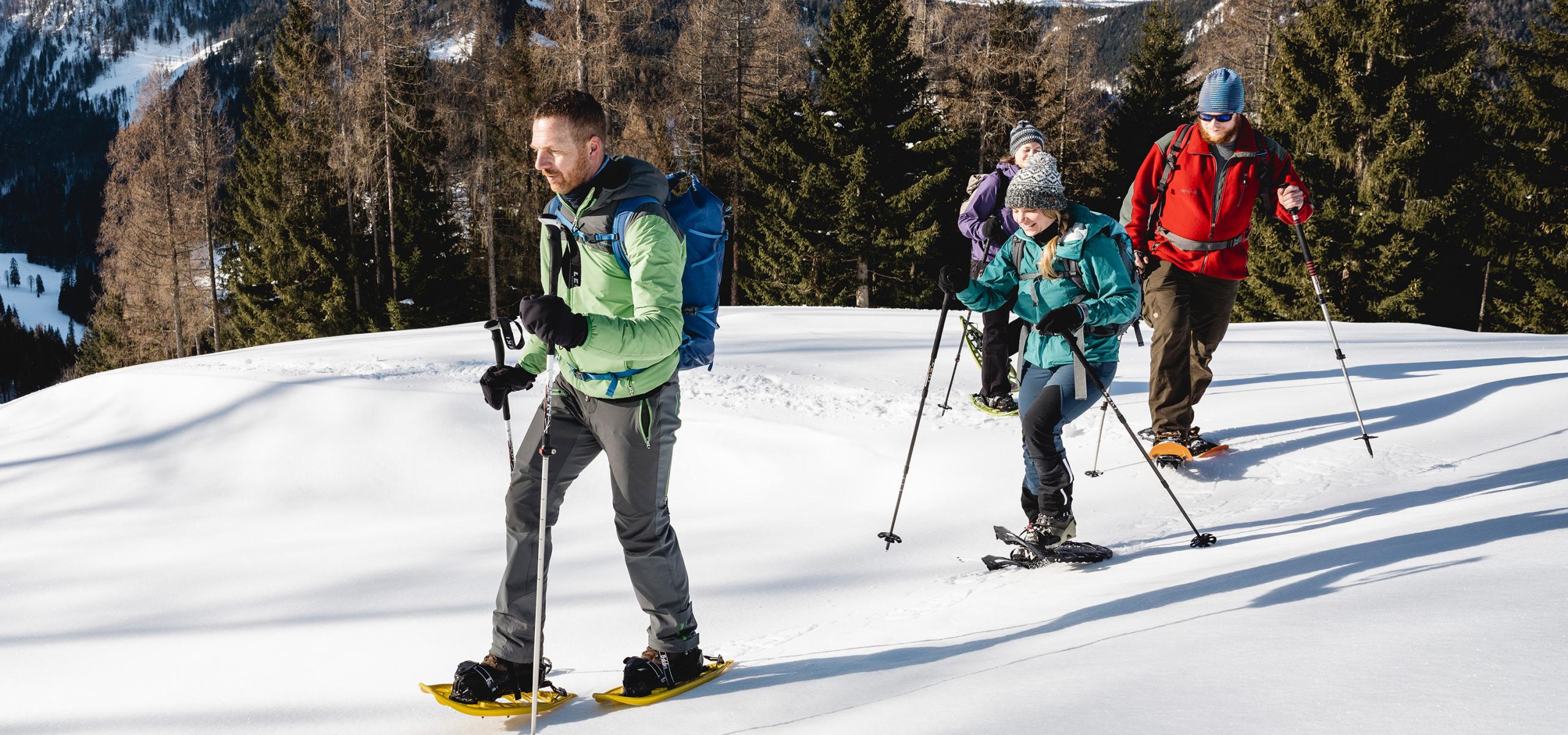 National Park Ranger accompanies three adults on a snowshoe hike