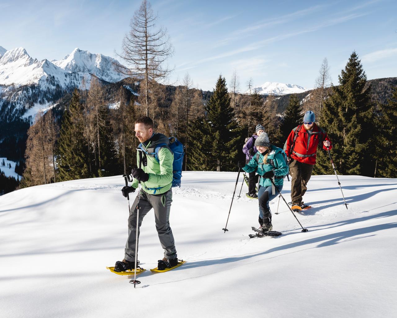 National Park Ranger accompanies three adults on a snowshoe hike