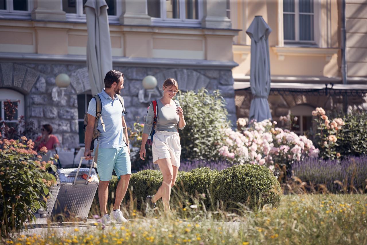 Man and woman arrive at hotel with backpacks and suitcases