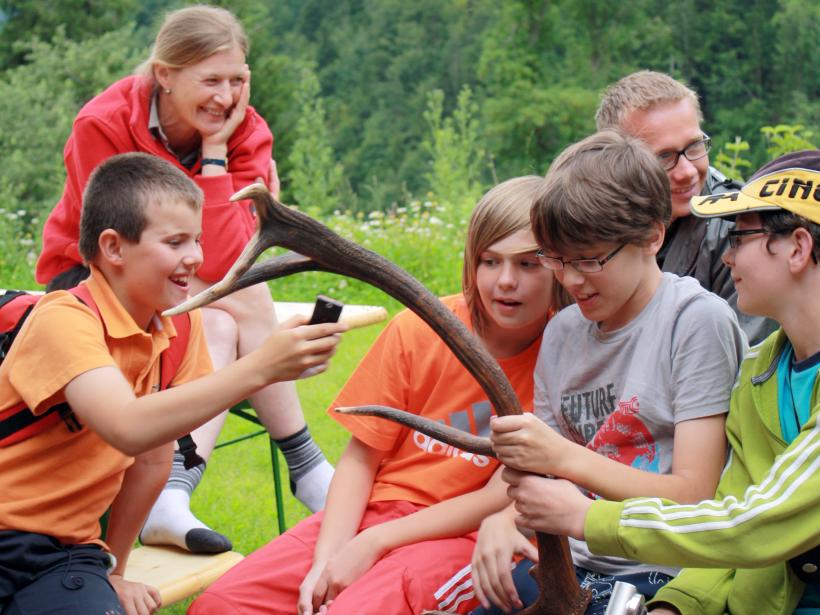 Young people hold a deer antler in their hands