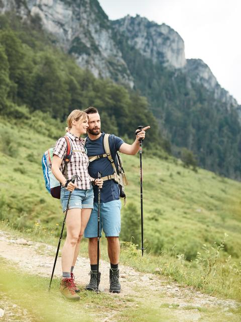 A woman and a man in hiking gear look around
