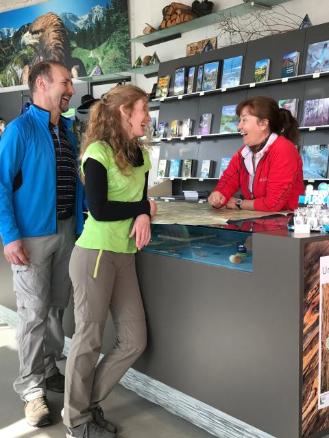 An employee advises two adults at the National Park Information Center