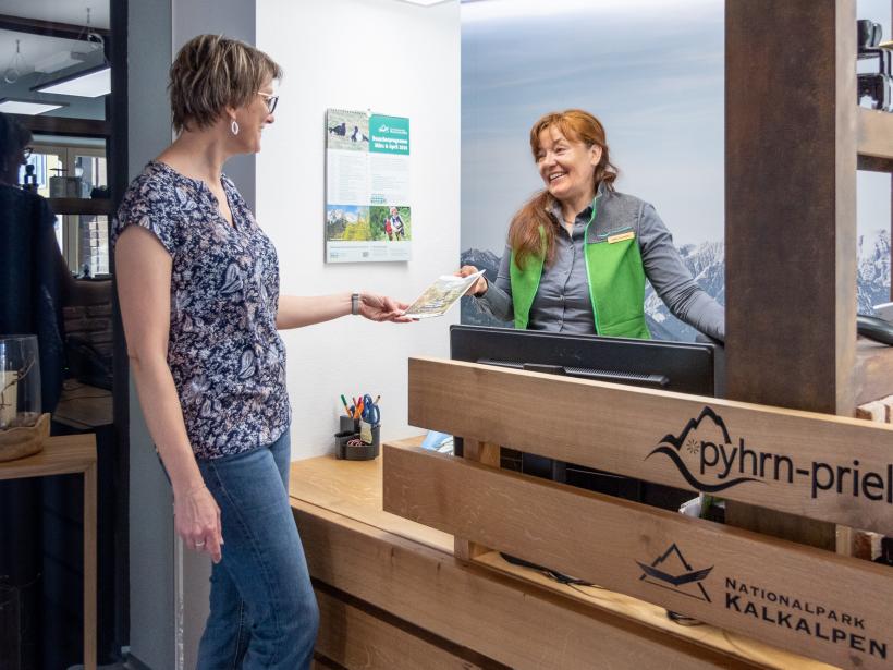 A National Park employee talks to a visitor at an information desk