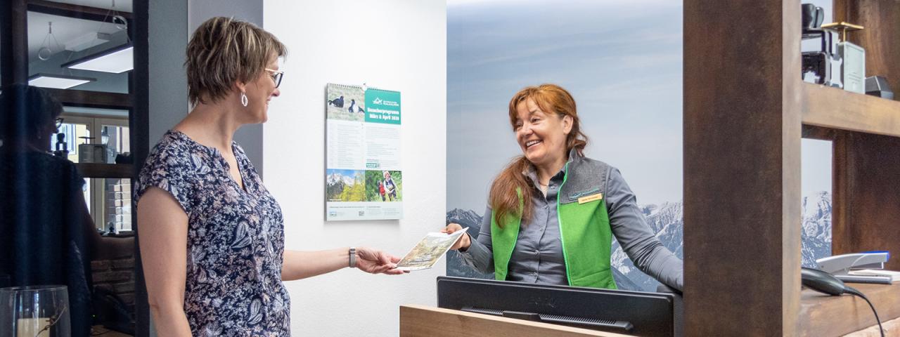 A National Park employee talks to a visitor at an information desk